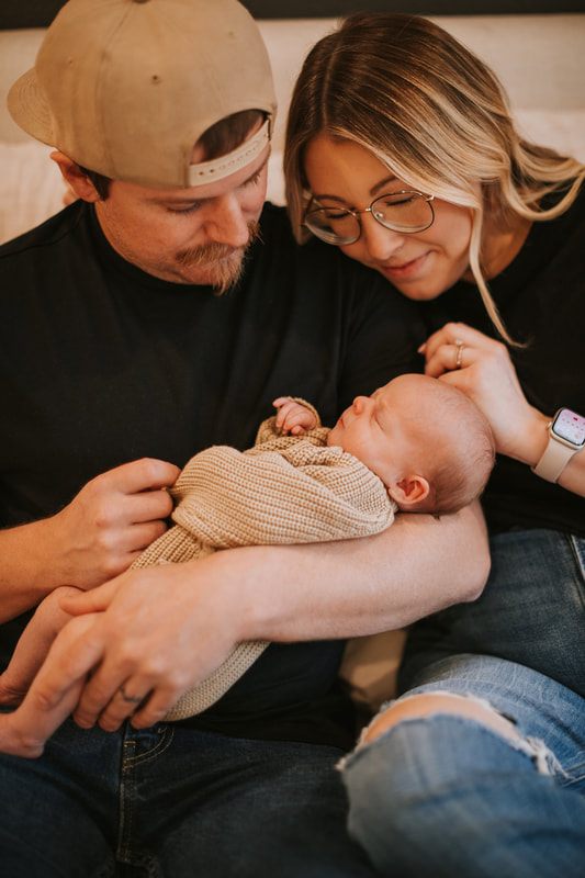 Family portrait of new parents with their newborn daughter at home