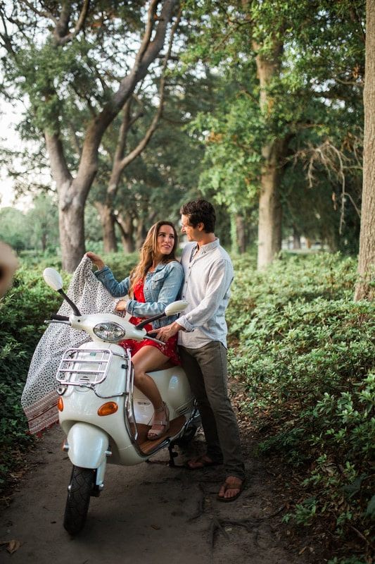 Couple posing beside their vespa scooter in historic Charleston