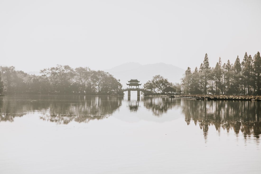 Traditional boat drifting across the still water of the West Lake in Hangzhou, China
