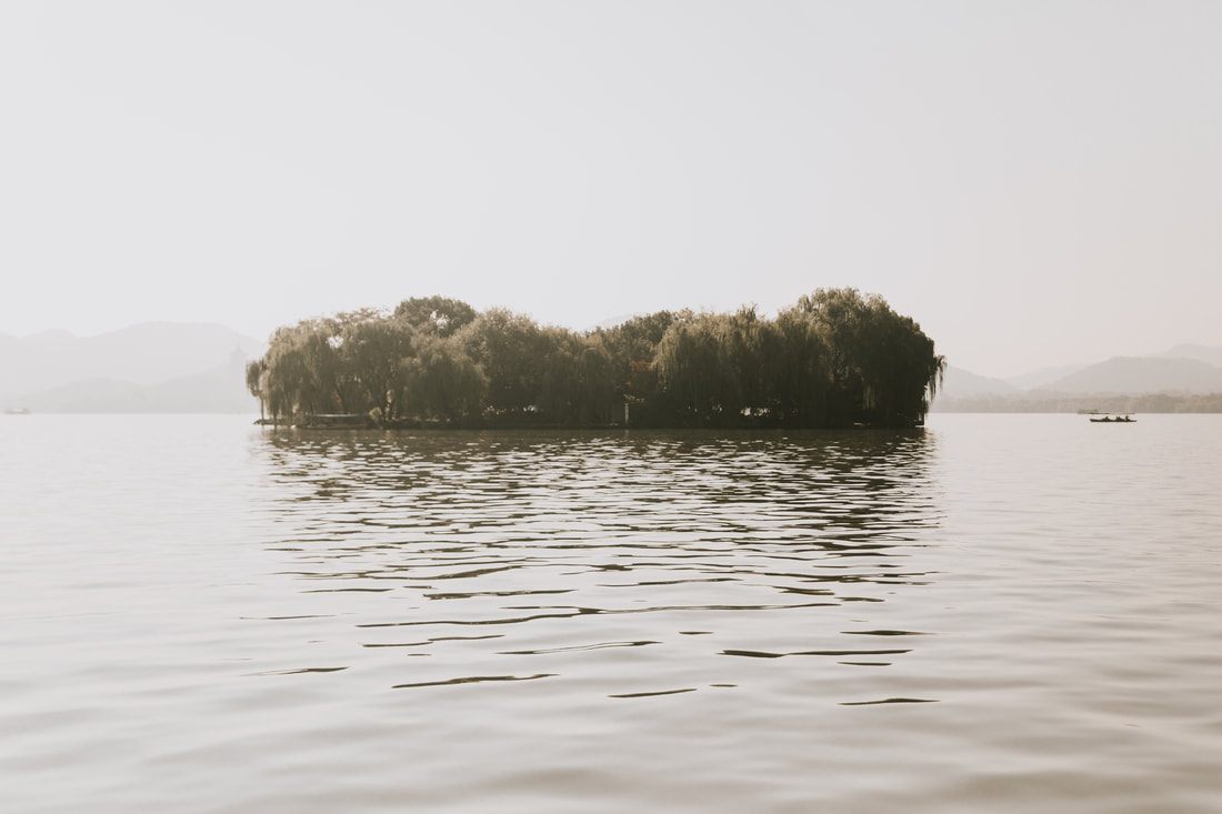 Misty morning view over Hangzhou's West Lake with pagodas in the distance