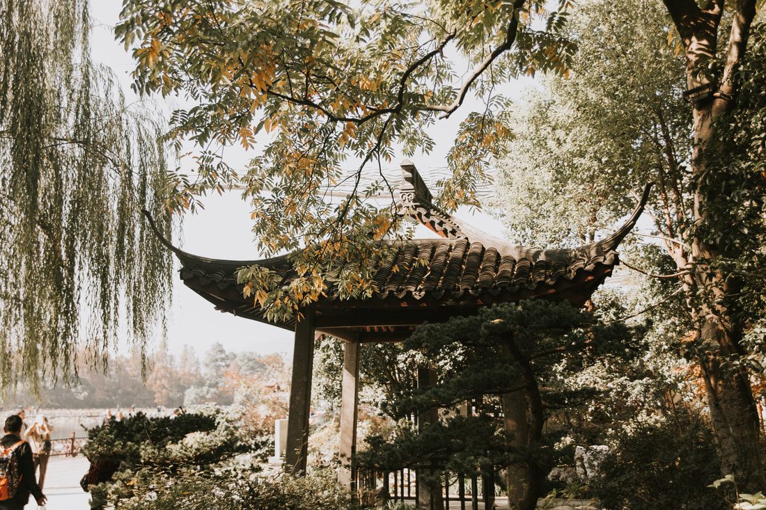 Traditional boat drifting across the still water of the West Lake in Hangzhou, China