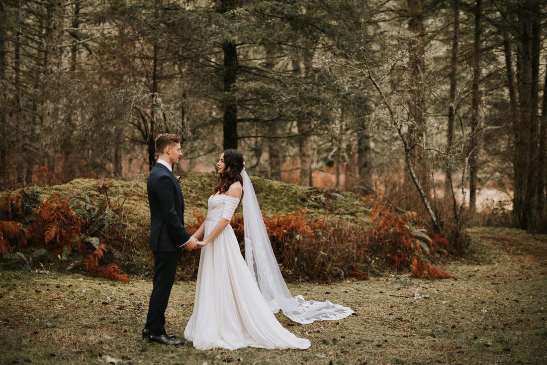 Bride and groom laughing together in the forest light