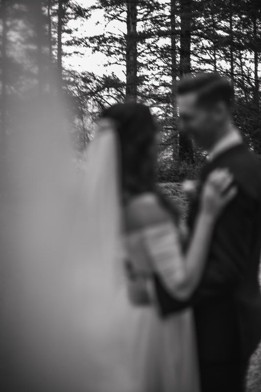 Newlyweds embracing surrounded by lush greenery on Orcas Island