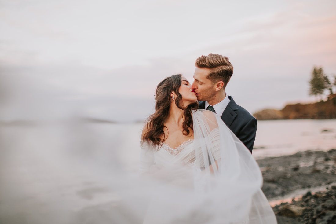 Newlyweds embracing surrounded by lush greenery on Orcas Island
