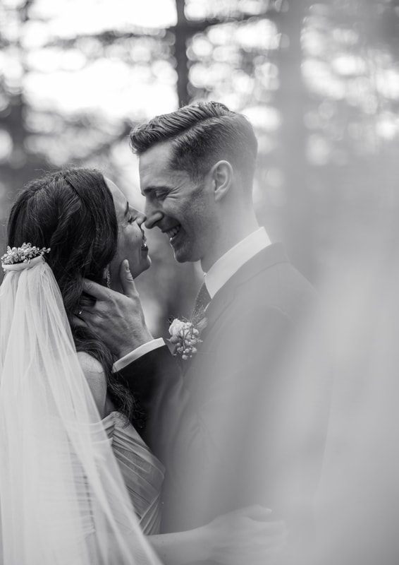 Newlyweds sharing a laugh during family portraits outside the chapel