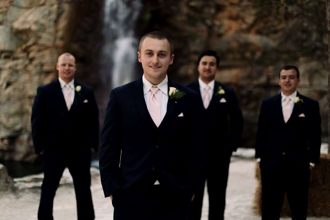 Bride twirling her dress in front of the cascading waterfall