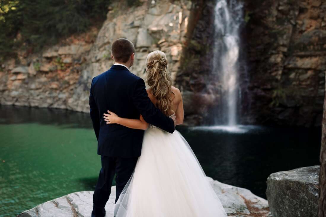 Bride and groom portrait beside a rushing waterfall near Charlotte, NC