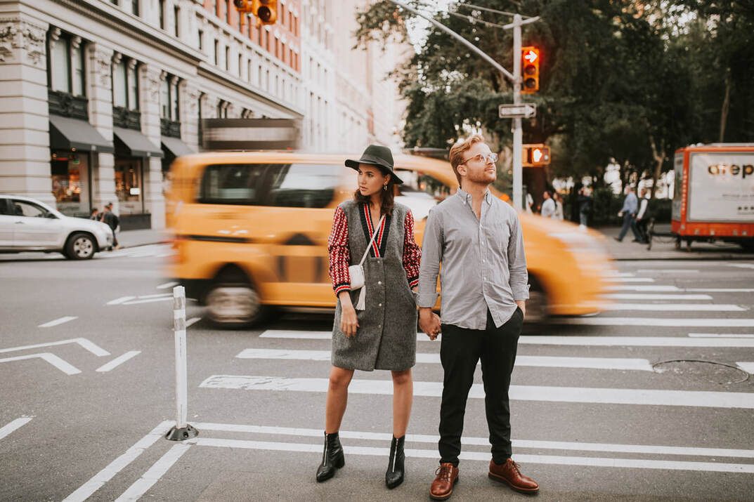 Couple embracing on a New York City street during a candid NYC engagement session