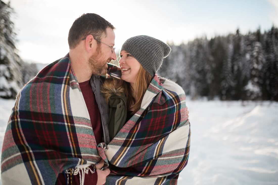 Close-up of the couple's clasped hands against a backdrop of fresh snow