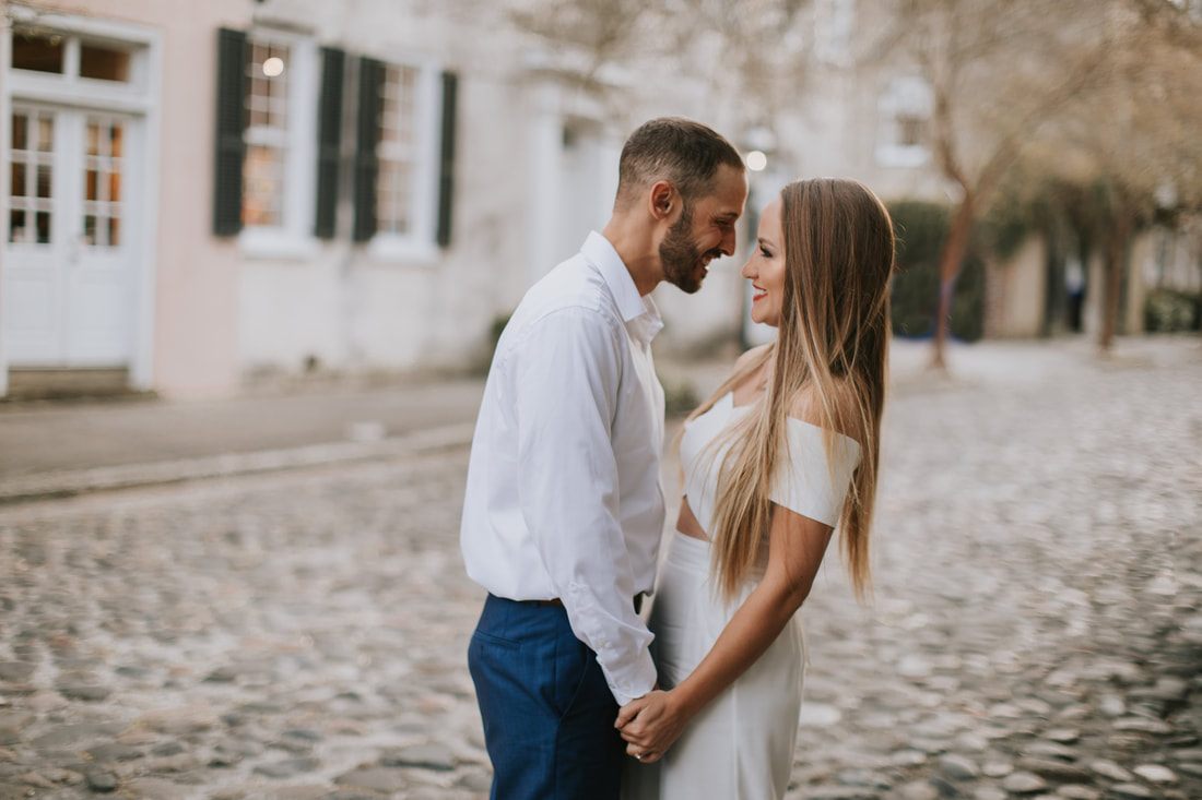 Couple holding hands while strolling the cobblestone streets of downtown Charleston