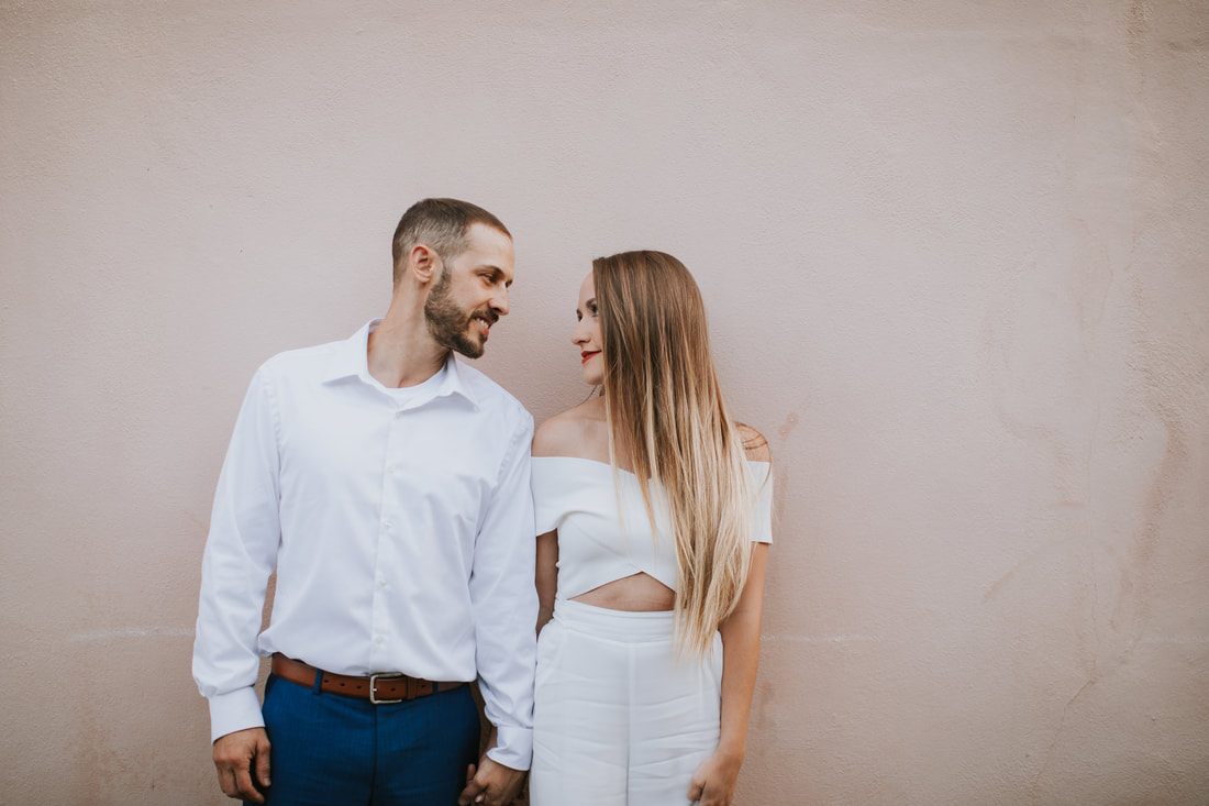 Engagement portrait in front of a wrought-iron gate in Charleston's historic district