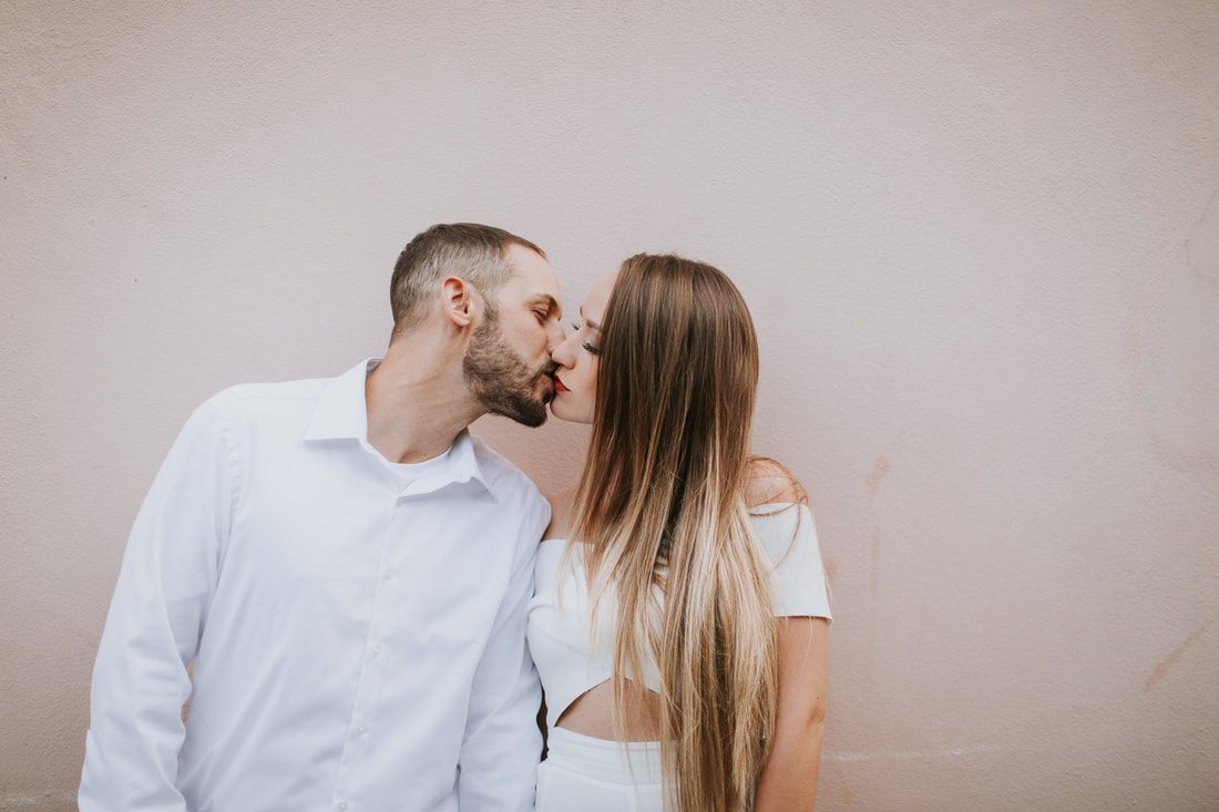 Candid laugh between an engaged couple on a downtown Charleston side street
