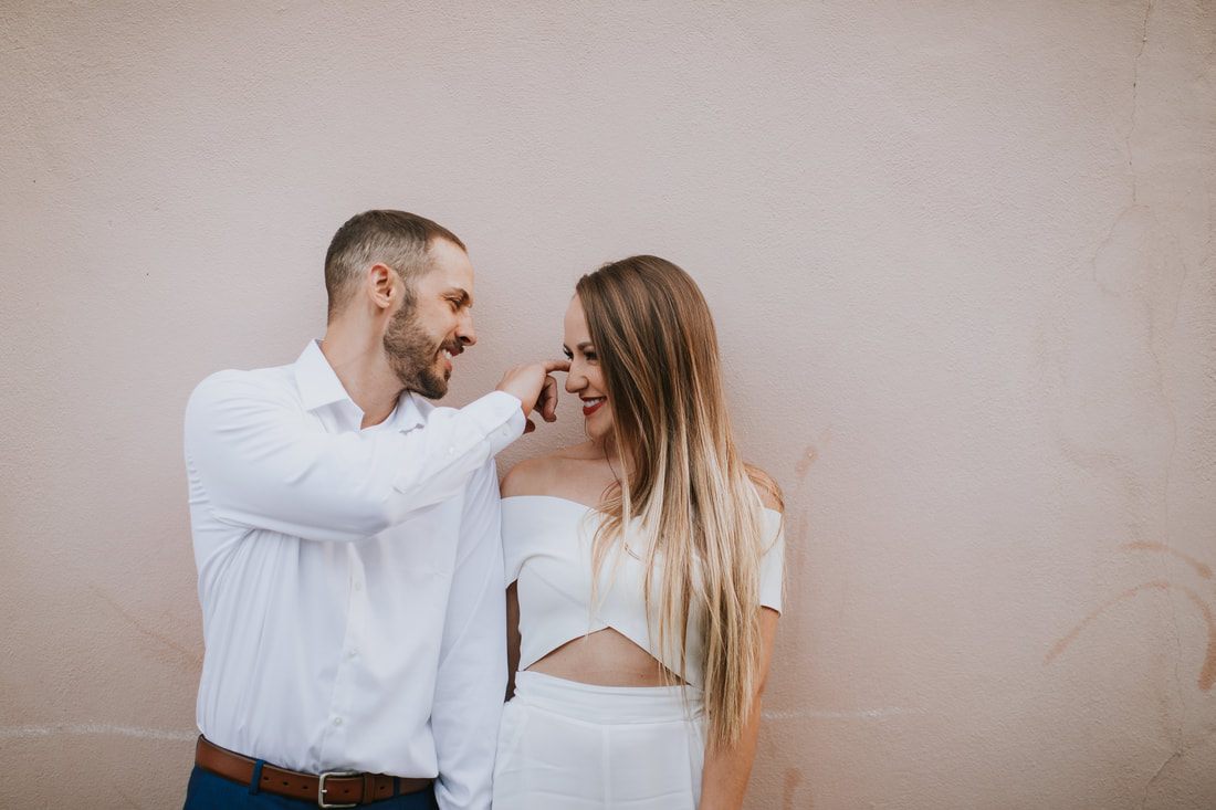 Couple leaning in for a kiss on a quiet Charleston cobblestone road