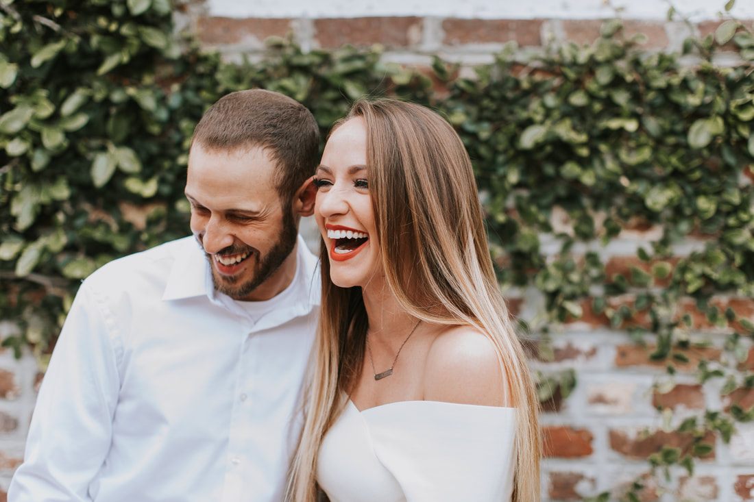 Engaged couple framed by pastel historic homes in downtown Charleston