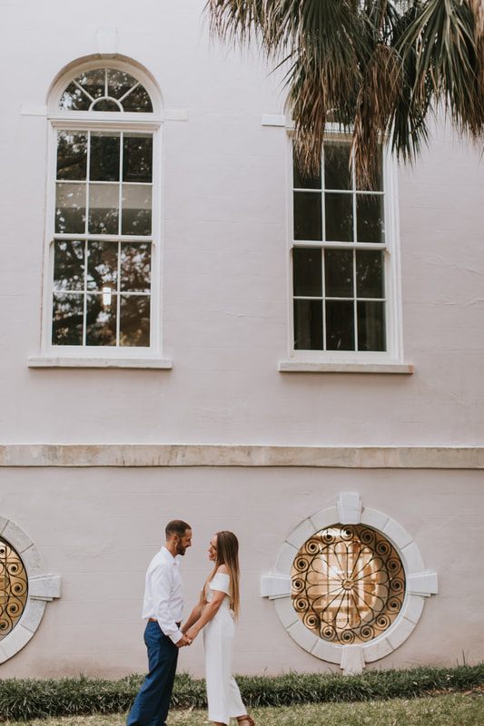 Engaged couple sharing a quiet moment on a brick sidewalk in Charleston