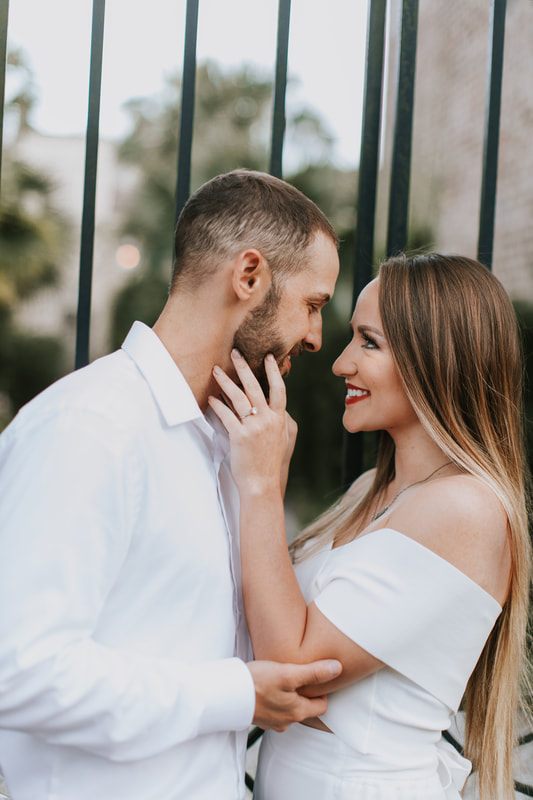 Engagement photo of a couple walking down a cobblestone alley in Charleston