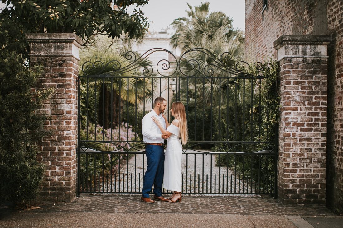 Couple holding each other close on a historic Charleston corner