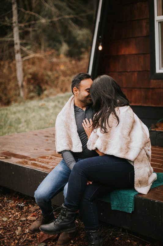 Engaged couple walking hand in hand near the greenhouse at the cabin