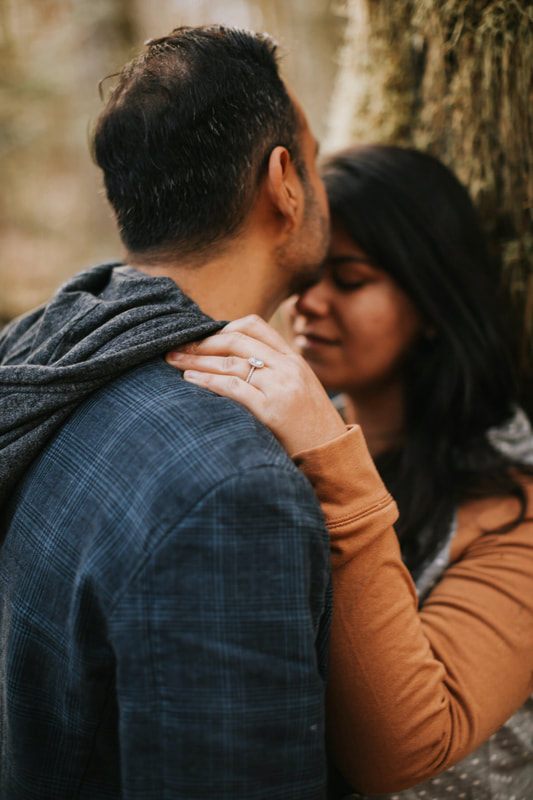Couple posed together against the a-frame cabin exterior