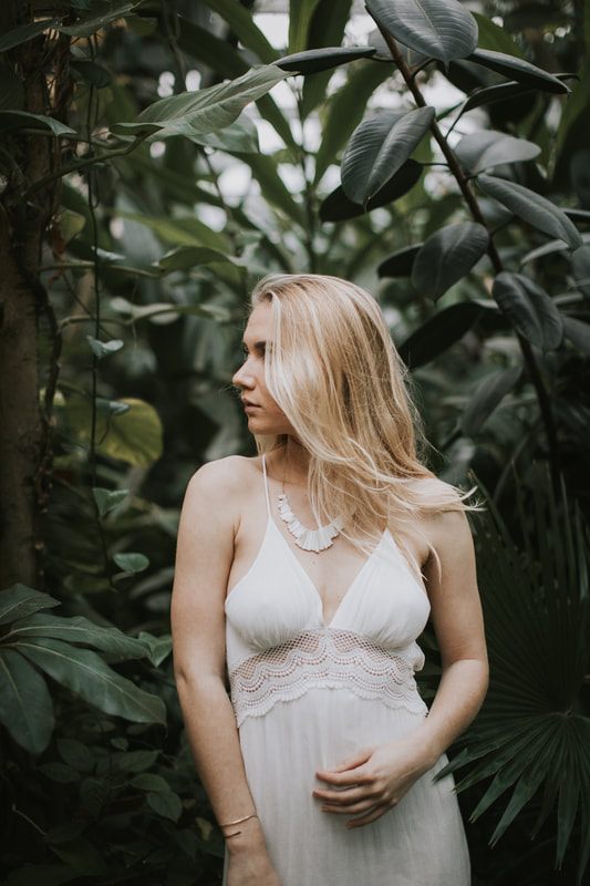Full-length portrait of Morgan styled among greenhouse greenery