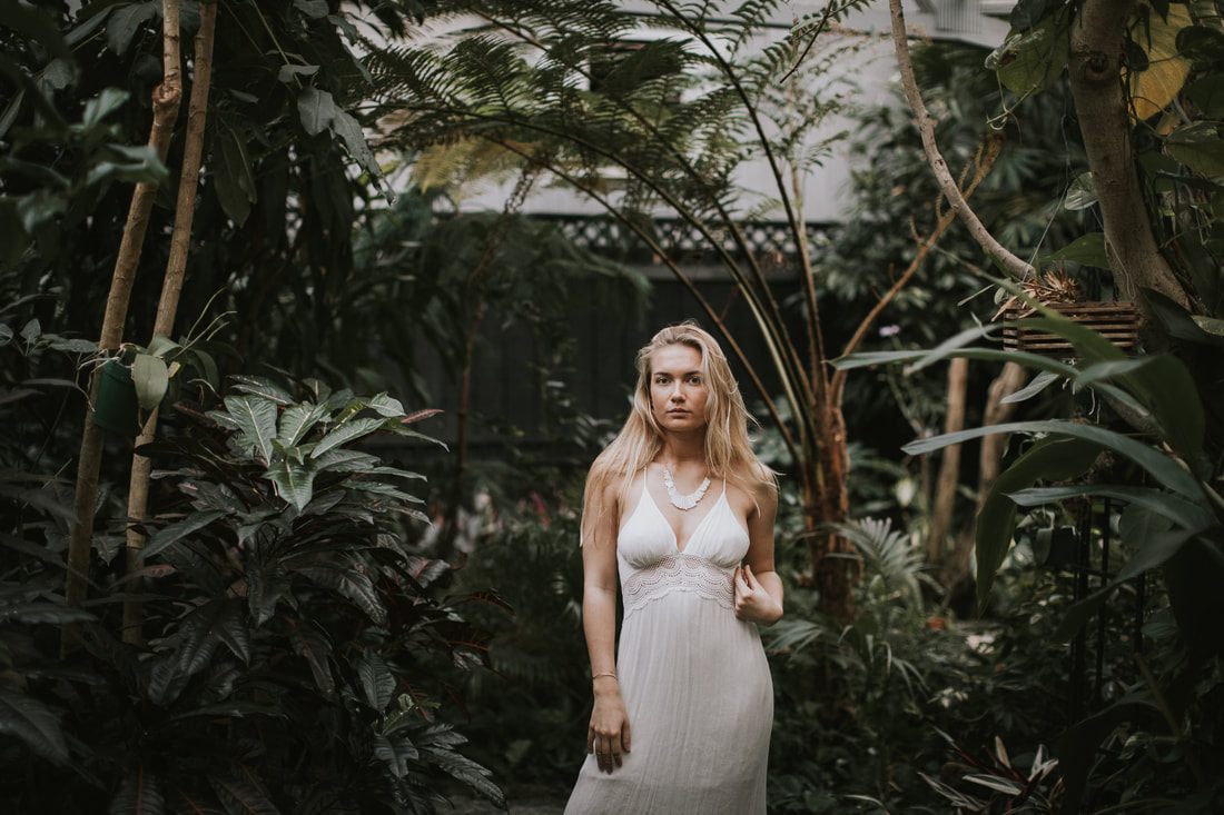 Candid portrait of Morgan smiling inside the greenhouse