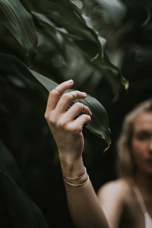 Portrait of Morgan surrounded by lush greenhouse foliage in Charleston