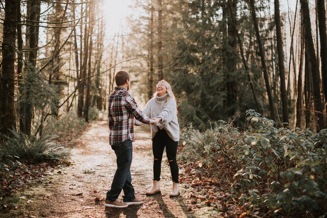 Engaged couple sitting on the grass by the Snoqualmie River
