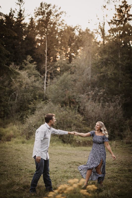 Couple laughing as chickens wander near them on the farm