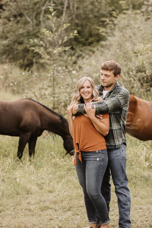 Couple standing beside their horse in a Snohomish pasture