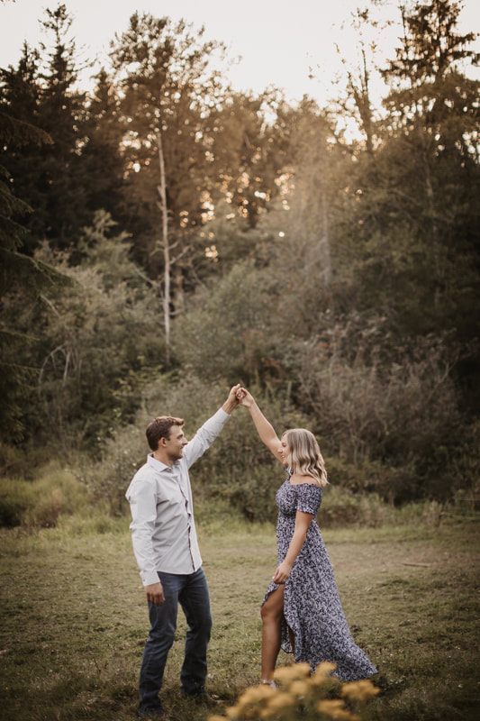 Couple standing among horses in a Snohomish pasture