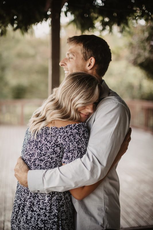 Engaged couple laughing together near their farmhouse