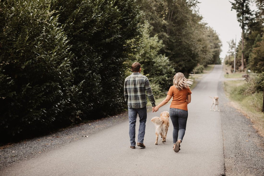 Engaged couple standing close together in a farm field