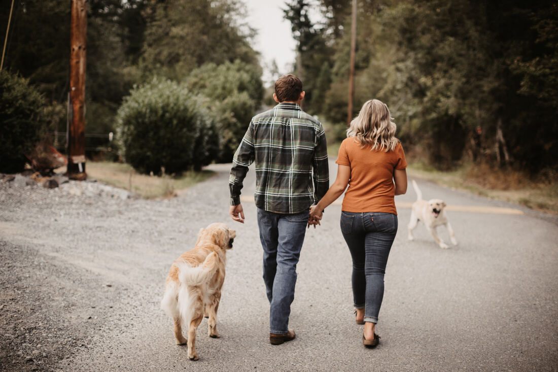Engaged couple walking toward the farmhouse at sunset