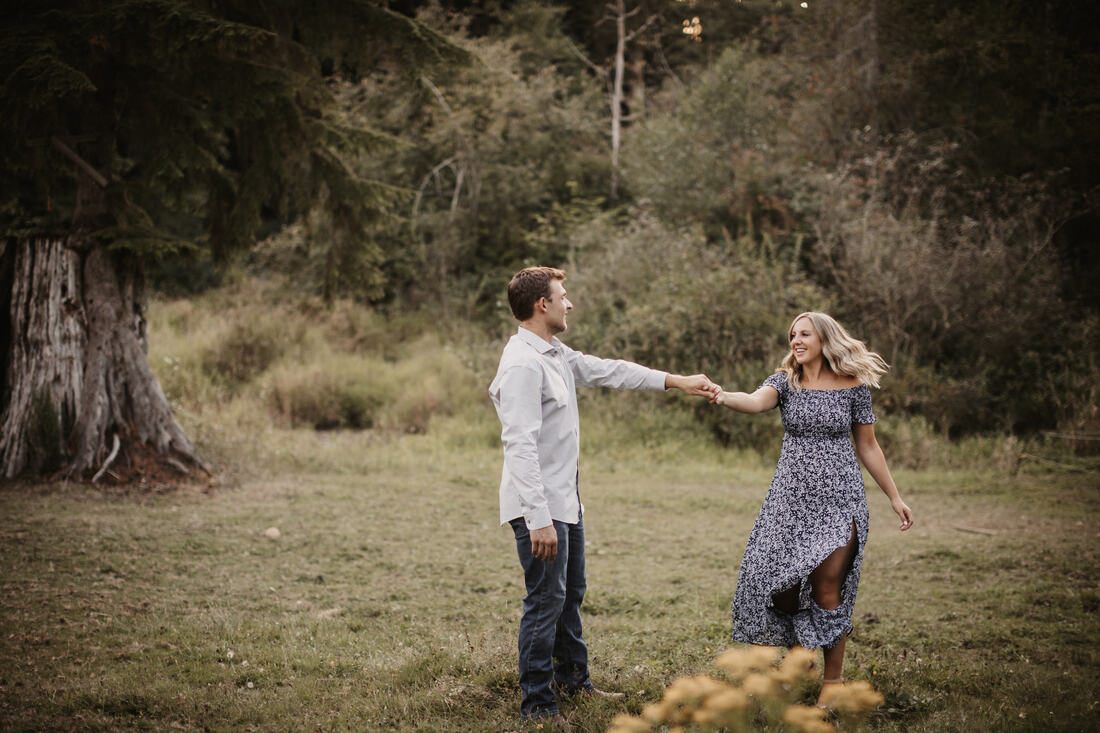 Couple walking together through a golden field at golden hour