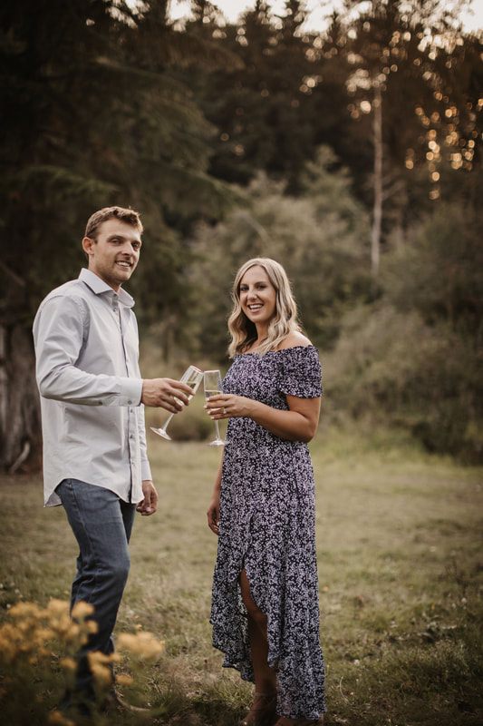 Engaged couple walking away together into the farm sunset