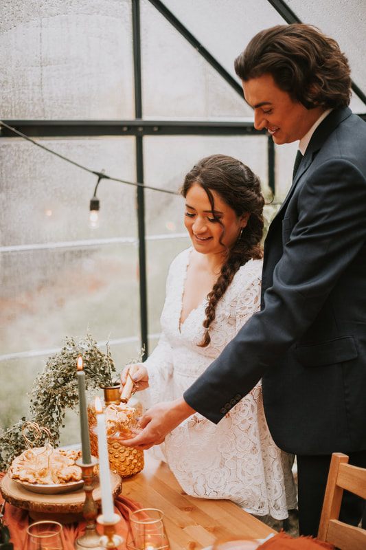 Bride laughing under an umbrella during her cabin elopement