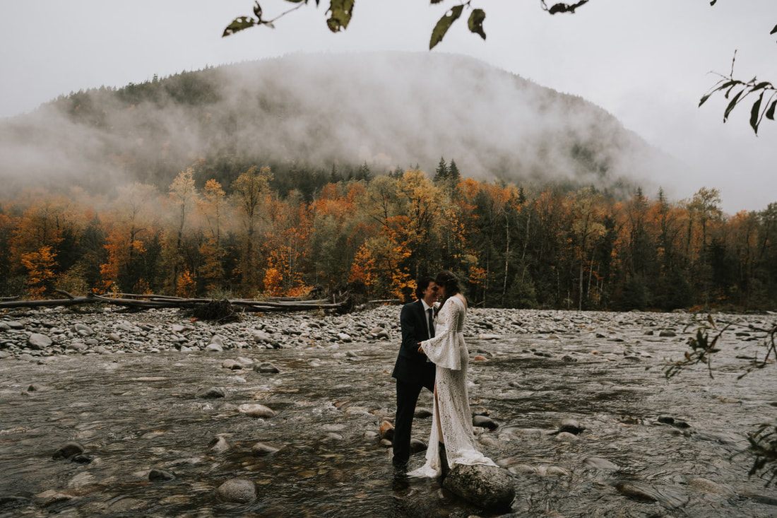 Close embrace between an eloping couple in front of the A-frame cabin