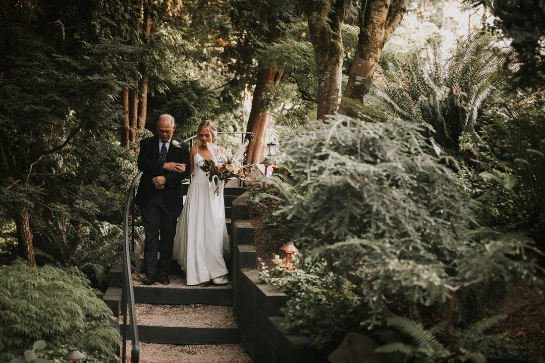The newlyweds sharing a quiet moment surrounded by dark, moody florals