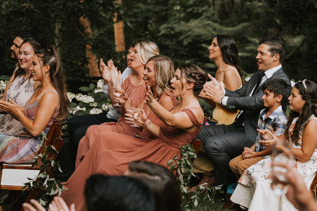 Katie dancing at the reception surrounded by dark, moody florals