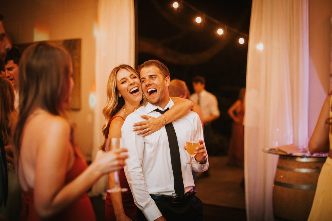 The bride and groom dancing at the reception in the winerys lush greenery