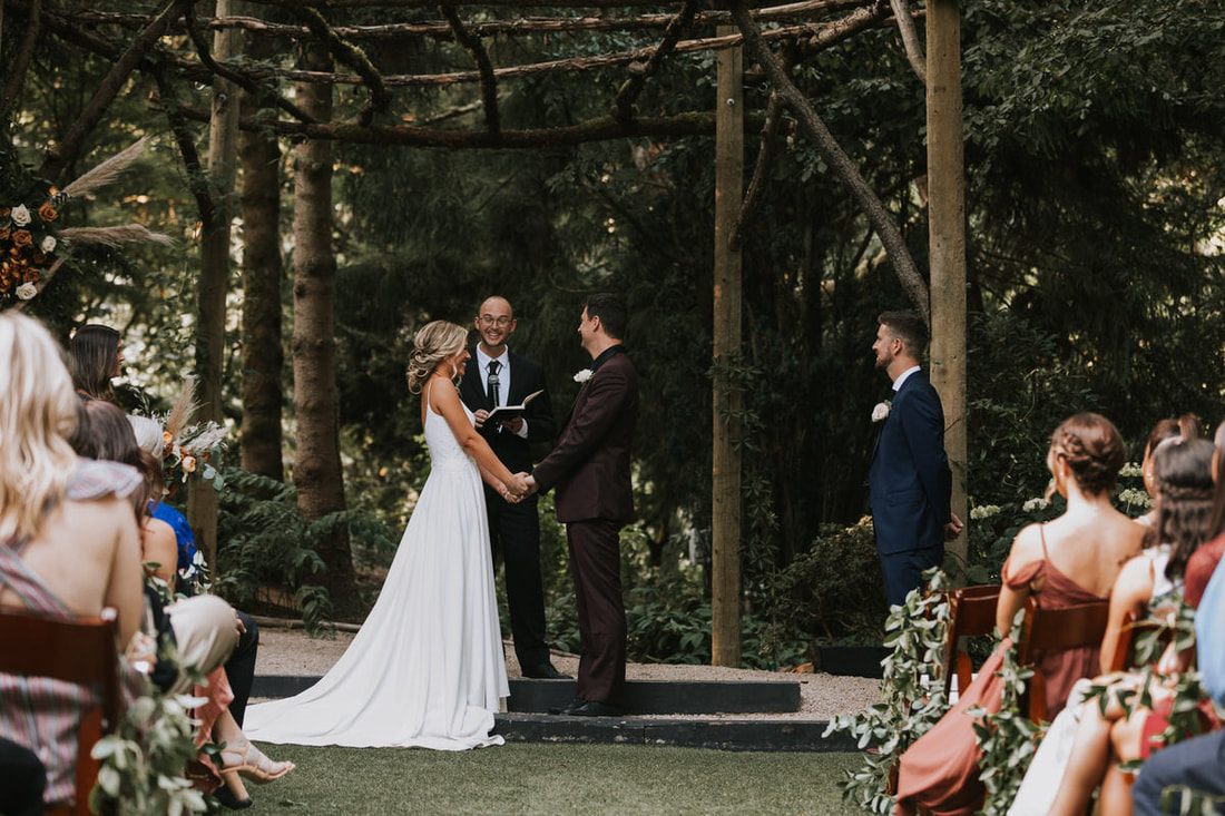 The bride and groom walking through the vineyard overlooking the Woodinville vineyard