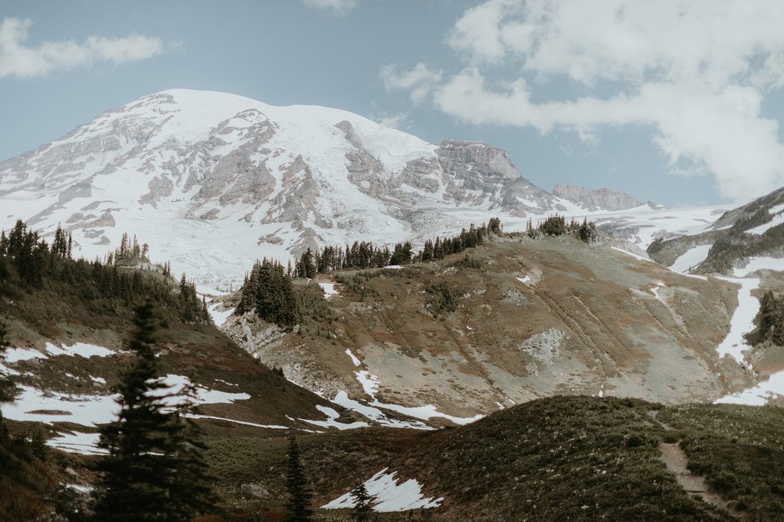 Snow covered Mount Rainier above subalpine meadows, one of the permit locations a Washington elopement photographer works in
