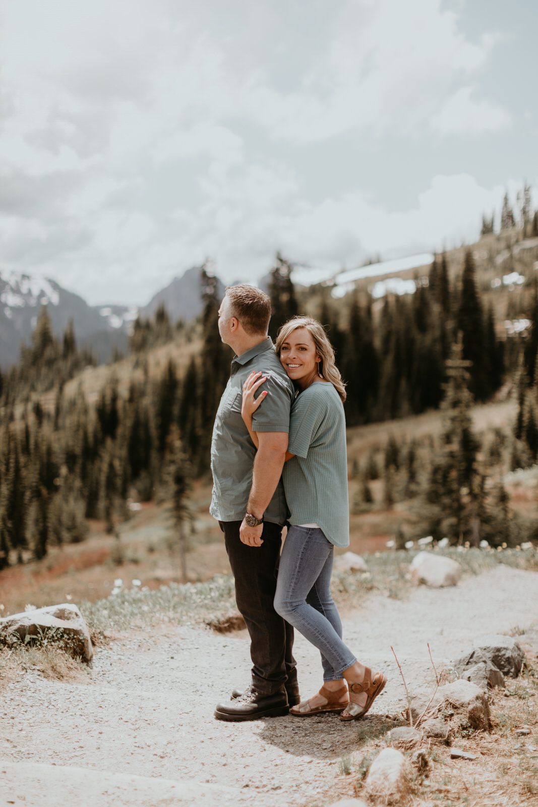Couple sitting together on a rocky outcrop with mountain views