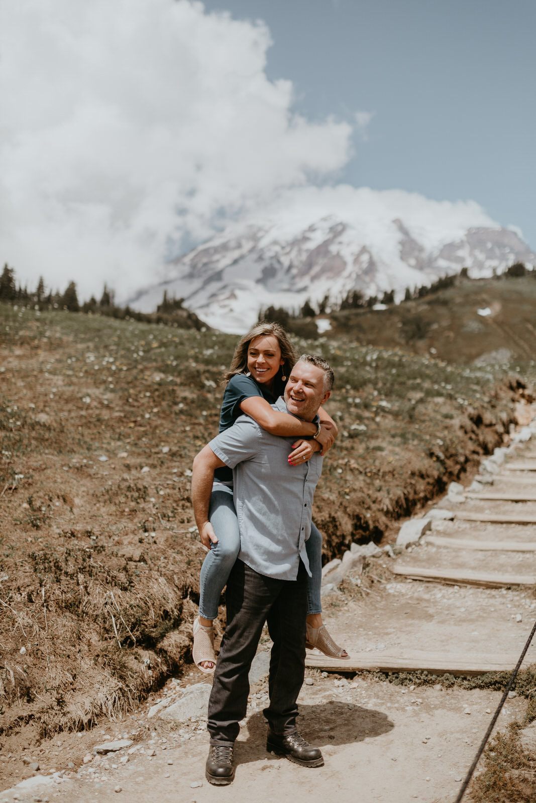 Close-up engagement portrait with wildflowers and mountain views