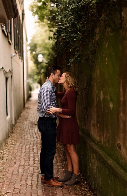 Close-up engagement portrait of Madison and Ashley on a Charleston side street