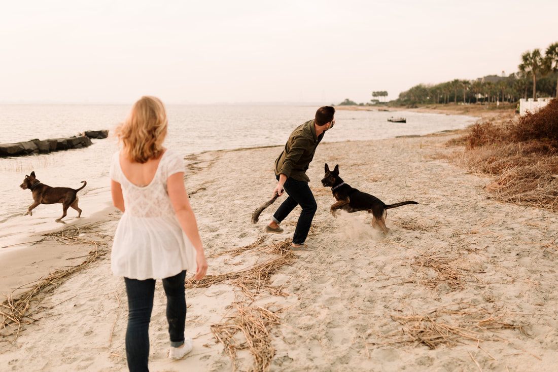 Madison and Ashley sitting on a bench on Sullivan's Island with their dogs