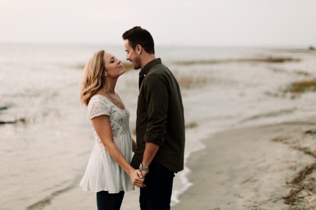 Engagement portrait of the couple on the beach with their dogs at their side