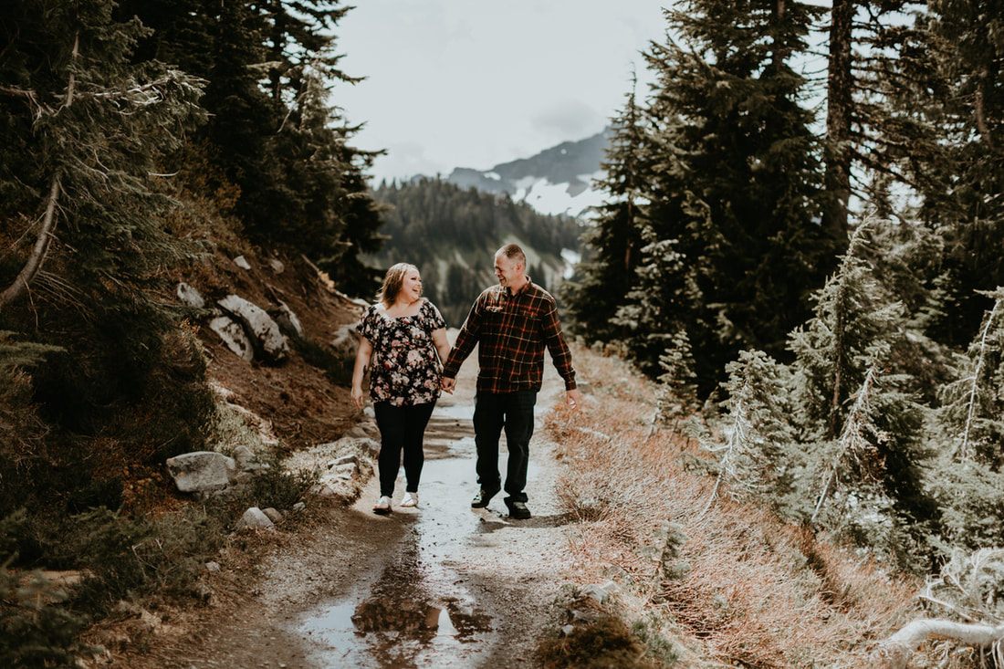 Engaged couple standing together with Mt. Rainier rising in the background