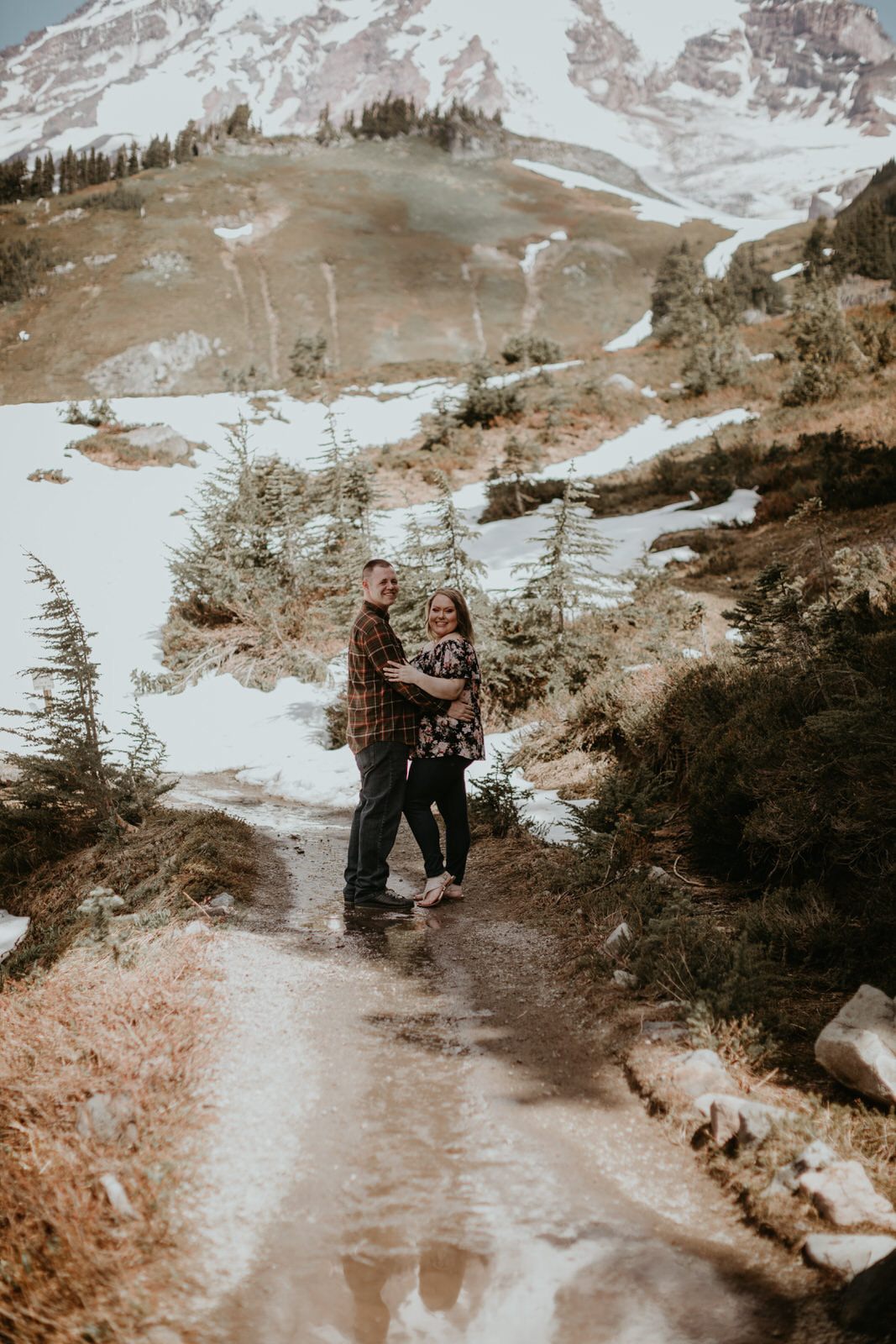 Engaged couple laughing together in a forested area near Mt. Rainier