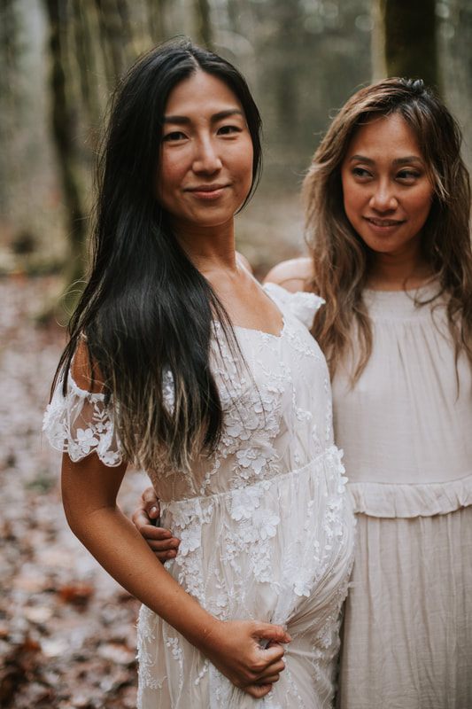 Two pregnant best friends standing side by side at the PNW cabin